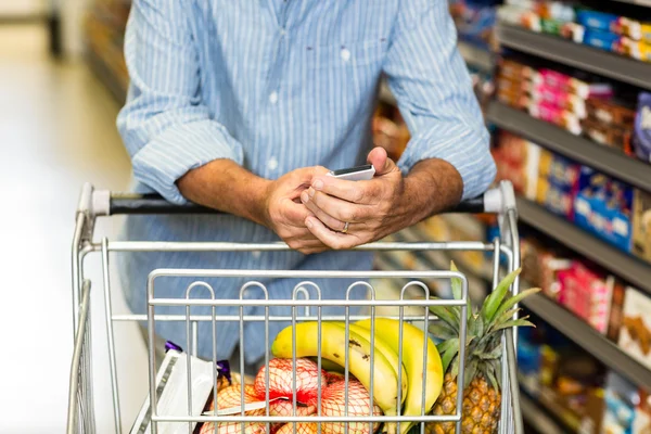 Man using phone at grocery store — Stock Photo, Image