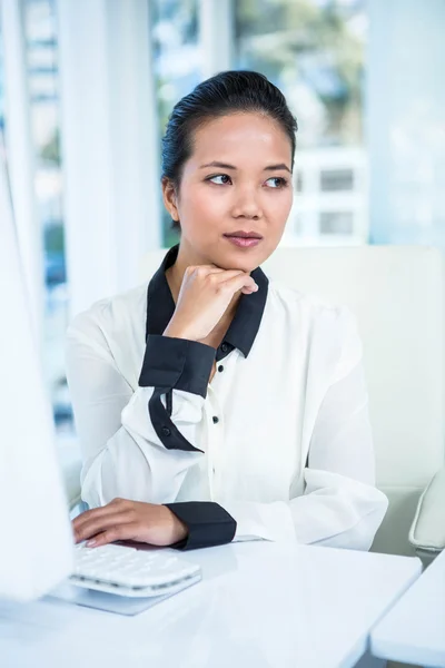 Leende affärskvinna att skriva på hennes dator — Stockfoto