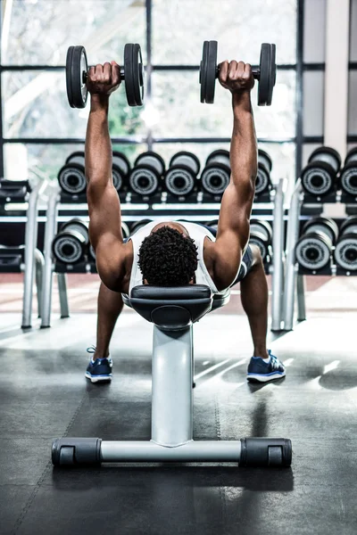 Homem muscular levantando halteres — Fotografia de Stock