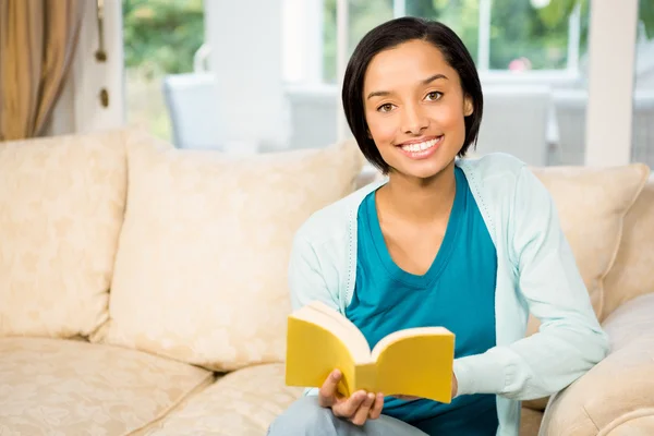 Bruna sorridente che legge un libro — Foto Stock