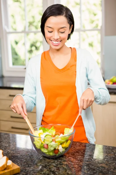 Uśmiechnięta brunetka przygotowanie sałatka — Zdjęcie stockowe