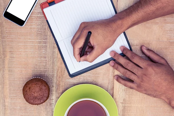 Homem escrevendo no diário à mesa — Fotografia de Stock