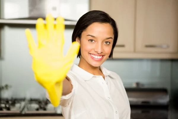 Lächelnde Brünette zeigt gelben Handschuh — Stockfoto