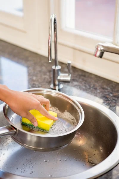 Woman washing pot in kitchen — Stock Photo, Image