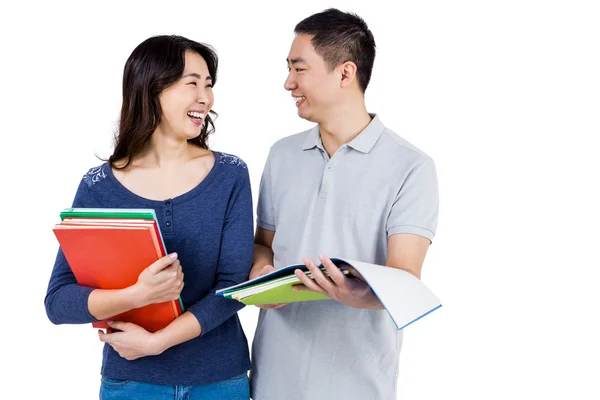 Couple smiling at each other while holding books — Stock Photo, Image