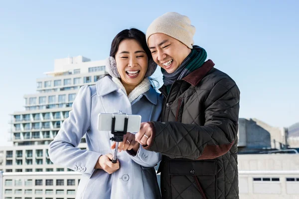 Pareja riendo mientras ve imágenes — Foto de Stock