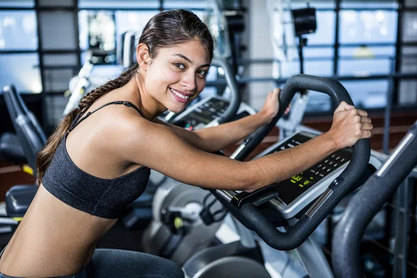 Sorrindo mulher apto fazendo exercício de bicicleta — Fotografia de Stock