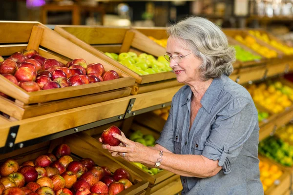 Χαμογελώντας ανώτερος γυναίκα να πάρει apple — Φωτογραφία Αρχείου