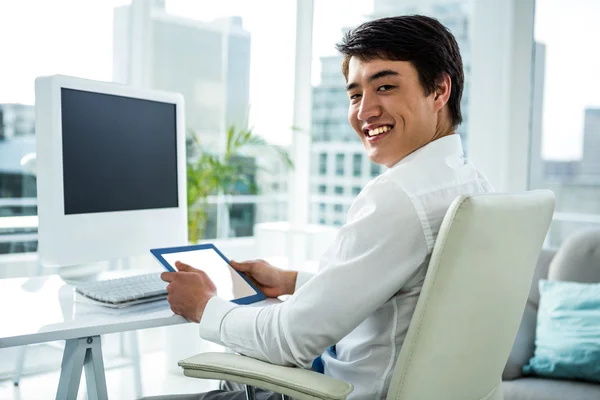 Lächelnder asiatischer Geschäftsmann mit seinem Tablet — Stockfoto