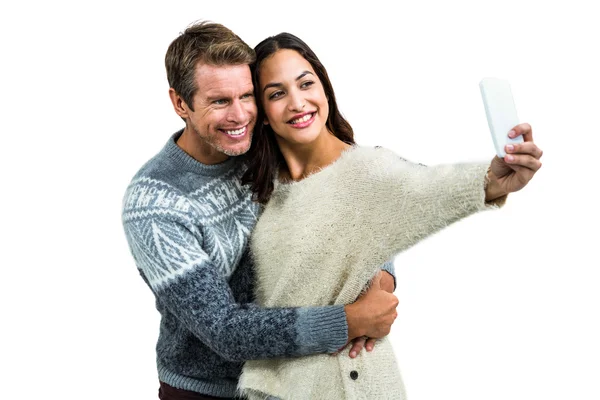 Happy couple wearing warm clothing taking selfie — Stock Photo, Image