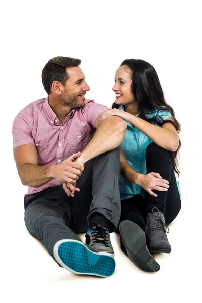 Casal feliz sentado enquanto olham um para o outro — Fotografia de Stock