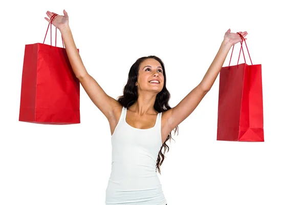 Smiling woman holding red shopping bags — Stock Photo, Image