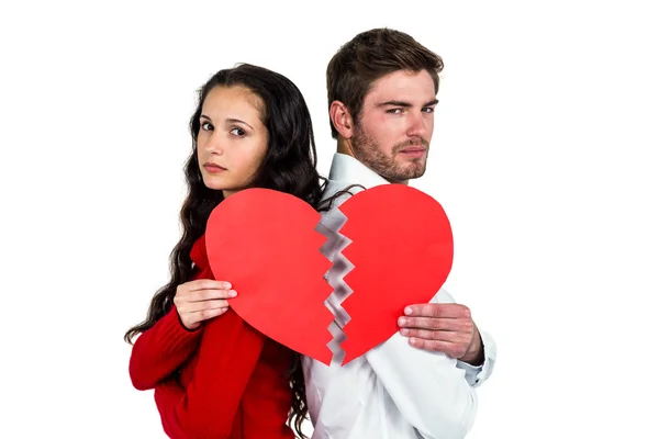 Casal de volta para trás segurando metades do coração — Fotografia de Stock