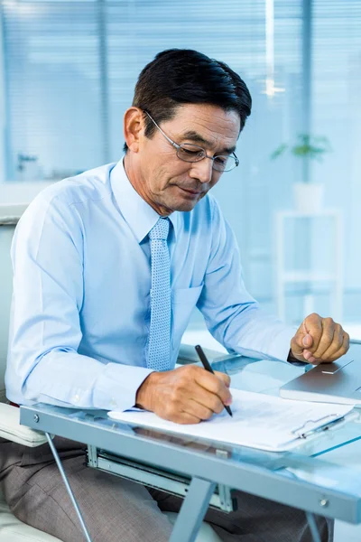 Enfocado asiático empresario escritura —  Fotos de Stock