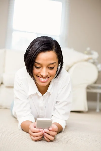 Smiling brunette using smartphone — Stock Photo, Image