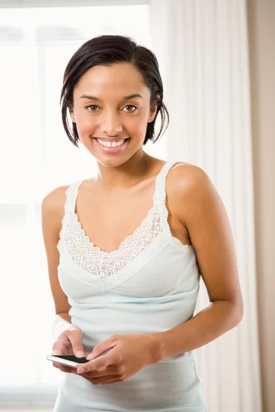 Smiling brunette using smartphone — Stock Photo, Image