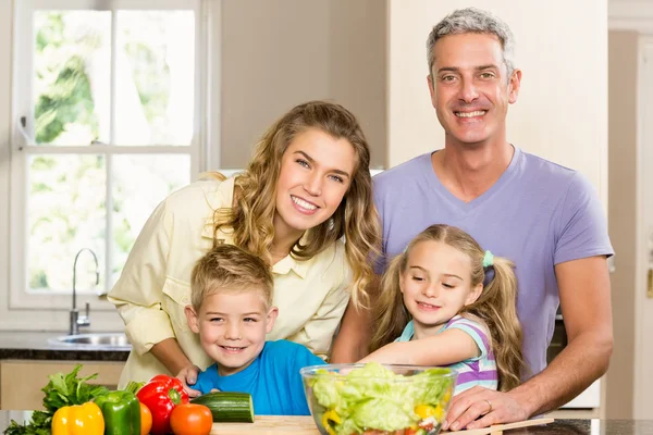 Счастливая семья готовит салат — стоковое фото