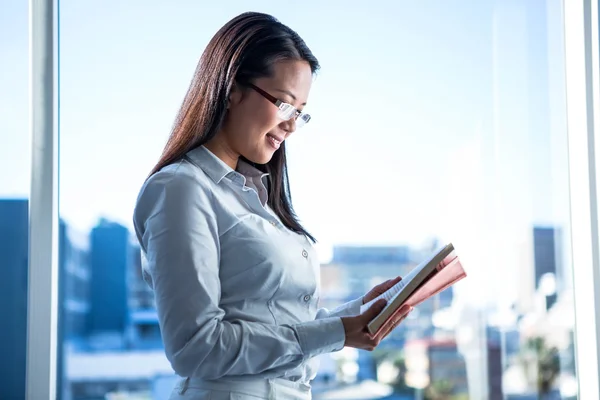 Mujer de negocios sonriente leyendo libro —  Fotos de Stock