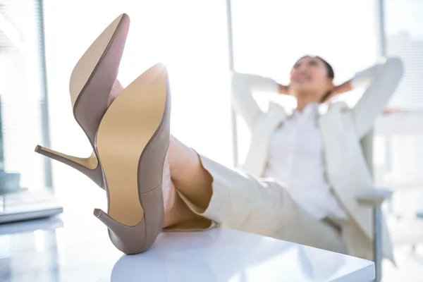 Расслабленная деловая женщина, сидящая с поднятыми ногами — стоковое фото