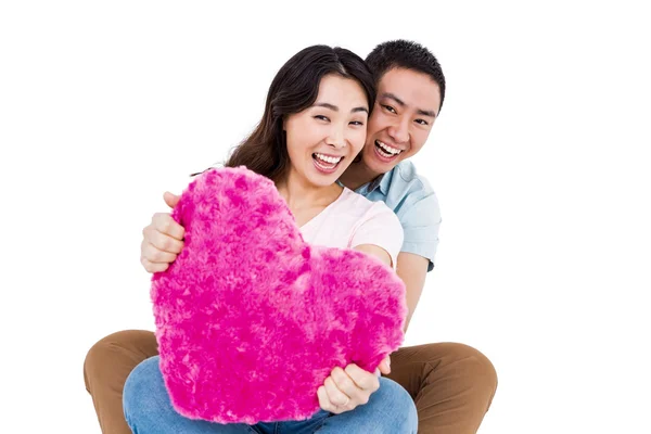 Veselý mladý pár s polštářem tvar srdce — Stock fotografie