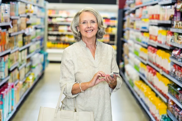 Sorridente donna anziana utilizzando smartphone — Foto Stock