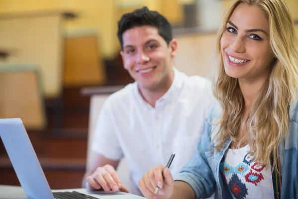 Smiling college students using laptop — Stock Photo, Image