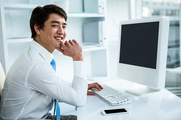 Leende asiatisk affärsman använder hans dator — Stockfoto