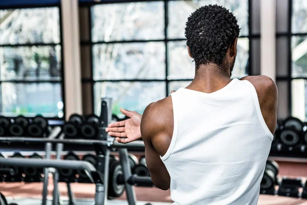 Homme étirant les bras à la salle de gym — Photo