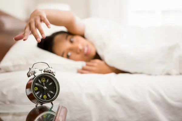 Relógio despertador contra morena na cama — Fotografia de Stock