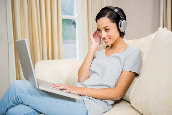 Brunette using laptop and headphones — Stock Photo, Image