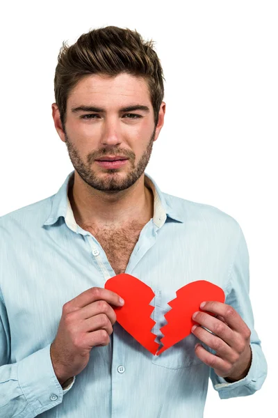 Грустный человек держит сердце половинки — стоковое фото