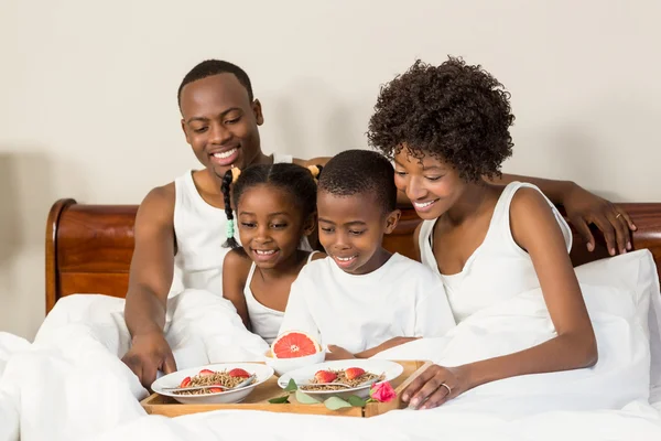 Família deitada na cama juntos — Fotografia de Stock