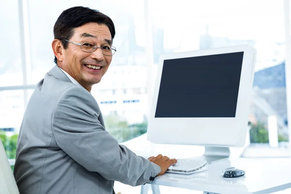 微笑的商人，用他的电脑 — 图库照片