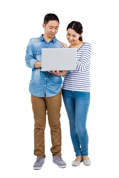 Feliz pareja usando el ordenador portátil — Foto de Stock