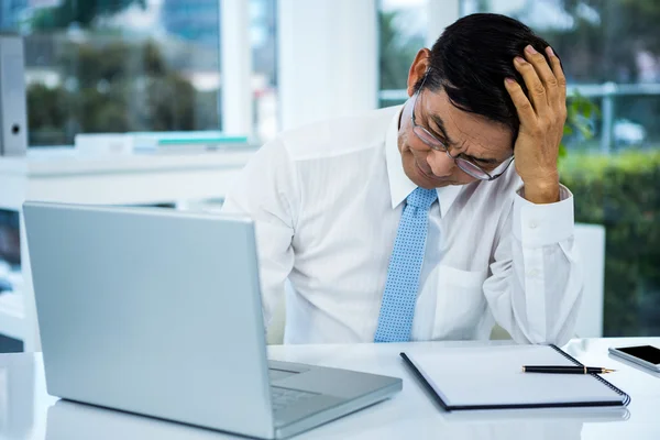 Besorgter Geschäftsmann am Schreibtisch — Stockfoto