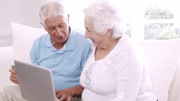 Усміхнена старша пара використовує ноутбук — стокове відео