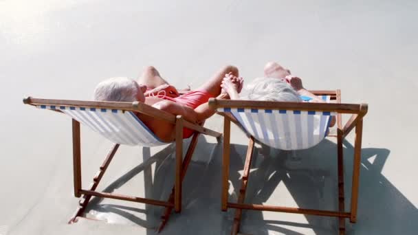 Voormalig oud koppel liggend op de strandstoel — Stockvideo