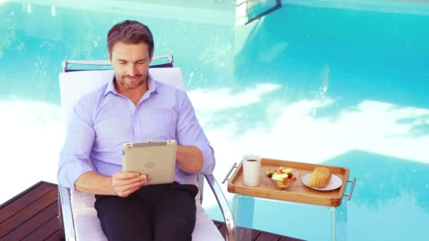 Homem bonito usando tablet na cadeira deck — Vídeo de Stock