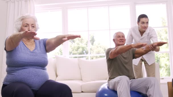 Infirmière souriante aidant couple de personnes âgées faire des exercices — Video