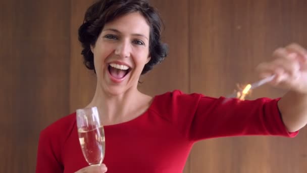 Жінка тримає іскру і келих шампанського — стокове відео