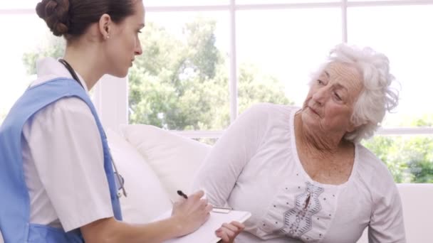 Старшая женщина разговаривает с медсестрой — стоковое видео