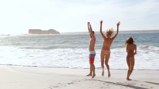 Amigos felizes pulando na praia — Vídeo de Stock