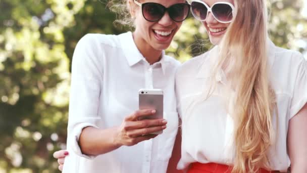 Amigos sonrientes con el uso de smartphone — Vídeo de stock