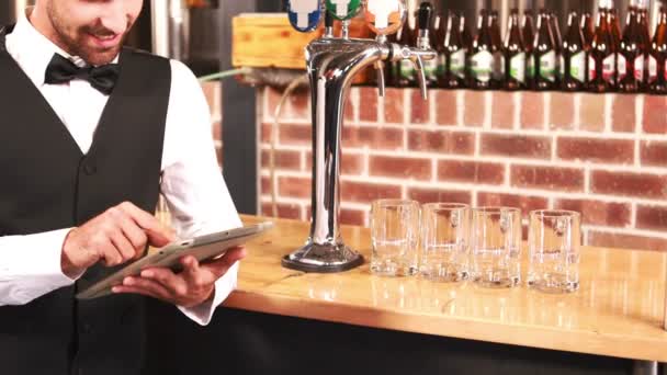 よくタブレットを使用して笑顔の barkeeper を服を着てください。 — ストック動画