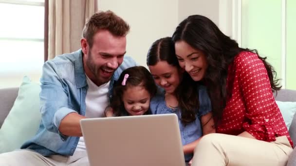 Happy family using laptop on sofa — Stock Video