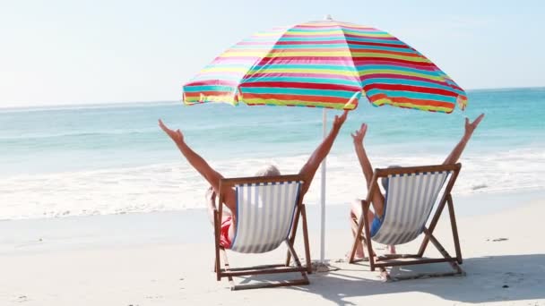 Retired old couple lying on deckchair while doing high five — Stock Video