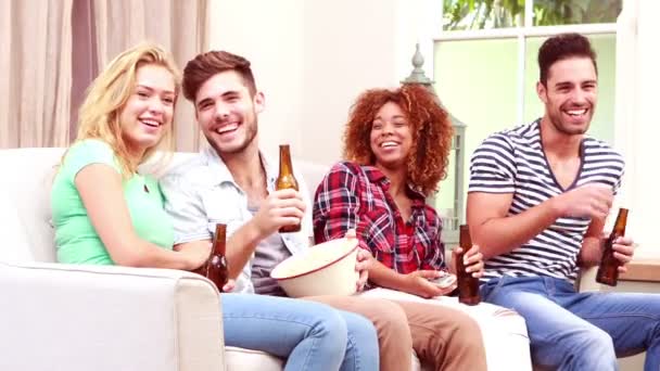 Друзья смотрят телевизор, когда едят кукурузу — стоковое видео