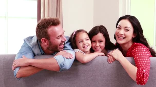 Familia sonriente posando en un sofá — Vídeos de Stock