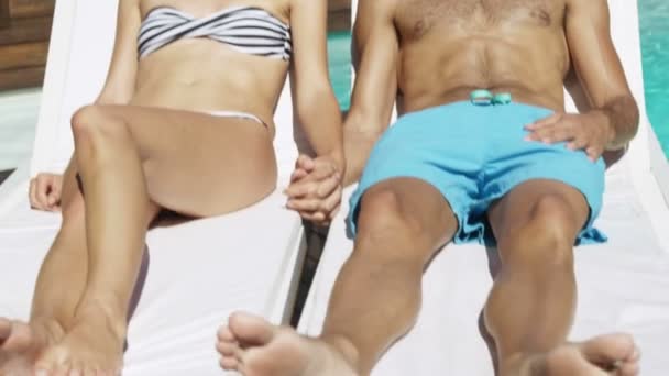 Happy couple lying on sun chairs — Stock Video