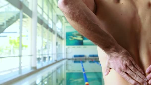 Rear view of a swimmer with back pain — Stock Video